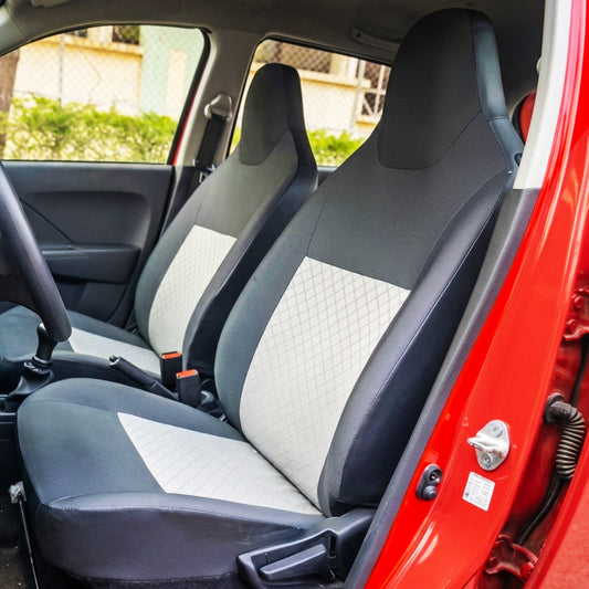 Gray and white quilted car seat covers in a red car interior.